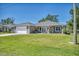 Charming single Gathering home featuring a manicured lawn, attached garage, and neutral-colored exterior at 16305 Branco Dr, Punta Gorda, FL 33955
