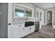Kitchen area with a stainless steel dishwasher, farmhouse sink, and wood flooring at 16305 Branco Dr, Punta Gorda, FL 33955