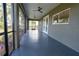 Screened patio with ceiling fans and access to backyard, featuring gray floors and windows at 16305 Branco Dr, Punta Gorda, FL 33955