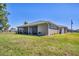 A well-kept lawn leads up to this home's outdoor living space with its screened in lanai and neutral paint at 16305 Branco Dr, Punta Gorda, FL 33955