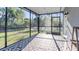 The screened-in porch has an outdoor rug covering the floor with views of the green backyard at 2784 Dode Ave, North Port, FL 34288