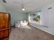 Cozy bedroom features carpet, neutral color walls, a ceiling fan, and a large window at 3341 Briant St, North Port, FL 34287