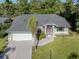 Charming single-story home featuring a well-manicured lawn, attached garage, and lush landscaping at 3341 Briant St, North Port, FL 34287