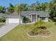 Inviting single-story home with lush landscaping, attached two-car garage and screened entry porch at 3341 Briant St, North Port, FL 34287