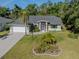 Charming single-story home with well-manicured lawn and tropical landscaping, featuring a two-car garage and screened entry at 3341 Briant St, North Port, FL 34287