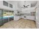 Well-lit kitchen with white appliances, tiled backsplash, and tile flooring, with views of the pool at 3341 Briant St, North Port, FL 34287