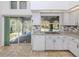 Bright kitchen features white cabinets, tiled countertops, and a view of the lanai and pool at 3341 Briant St, North Port, FL 34287
