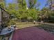 Outdoor patio with brick pavers has a seating area and is surrounded by a fence and mature trees, offering privacy at 3341 Briant St, North Port, FL 34287