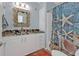 Charming bathroom with ornate mirror, decorative shower curtain and granite countertops at 4297 Nettle Rd, Port Charlotte, FL 33953