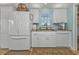 Bright kitchen with white appliances, a double-door refrigerator, and granite countertops at 4297 Nettle Rd, Port Charlotte, FL 33953