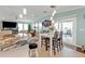 Open living and dining area with tiled floors, bright pendant lights, and sliding glass doors to patio at 4297 Nettle Rd, Port Charlotte, FL 33953