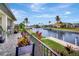 Backyard view featuring a waterfront canal, lush landscaping, and private dock at 5221 Almar Dr, Punta Gorda, FL 33950