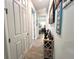 Hallway featuring wood-look tile flooring, art displays, and neutral wall paint throughout at 8117 Thruso Rd, Port Charlotte, FL 33981