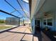 Outdoor patio with brick pavers, a ceiling fan, and a view of the screened-in lanai and backyard at 8117 Thruso Rd, Port Charlotte, FL 33981