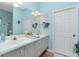Bright bathroom with double vanity, mirrors, and blue accents at 8242 Lakeside Dr, Englewood, FL 34224