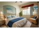 Bright bedroom with coastal decor, large window, and wicker chair at 8242 Lakeside Dr, Englewood, FL 34224