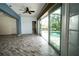 Open living space with wood-look flooring, sliding glass doors to the pool, and a ceiling fan at 8242 Lakeside Dr, Englewood, FL 34224