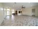 Open-concept living area with tile flooring, ceiling fan, and views of the kitchen and front entry at 8242 Lakeside Dr, Englewood, FL 34224