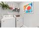 Bright laundry room featuring a Whirlpool washer/dryer and decorative wall art at 9452 Sunbeam Cir, Punta Gorda, FL 33950