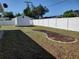 Spacious backyard with a white vinyl fence, storage shed, and a mulched landscaping bed at 1057 Staley St, Port Charlotte, FL 33952