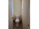 Small powder room featuring a toilet, tile floors, and a white door at 1057 Staley St, Port Charlotte, FL 33952