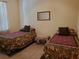 Bedroom with two twin beds, neutral walls, tile floors, and simple mirror at 1057 Staley St, Port Charlotte, FL 33952