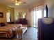 Bright bedroom with sliding glass door, neutral walls, tile floors and ceiling fan at 1057 Staley St, Port Charlotte, FL 33952