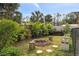 Outdoor backyard with a fire pit, lush greenery, and a wooden fence at 1845 Edison Dr, Englewood, FL 34224
