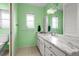 Bright bathroom featuring marble counters, updated fixtures, and green walls at 1845 Edison Dr, Englewood, FL 34224