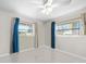 A clean and spacious bedroom with tile flooring, ceiling fan, and natural light at 1845 Edison Dr, Englewood, FL 34224