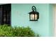 Charming exterior detail of the house address and lantern against a turquoise wall at 1845 Edison Dr, Englewood, FL 34224