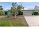 Charming single-story home featuring a well-maintained front yard, two-car garage, and beautiful turquoise exterior at 1845 Edison Dr, Englewood, FL 34224