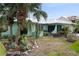 Charming home with lush landscaping, a metal roof, and a screened-in lanai at 1845 Edison Dr, Englewood, FL 34224