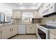 Functional kitchen with white cabinets and appliances, overlooking the dining and living areas at 1845 Edison Dr, Englewood, FL 34224
