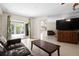 Open concept living room with tile flooring, a sliding door to a screened lanai and pool, and a modern entertainment center at 1845 Edison Dr, Englewood, FL 34224