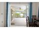 View from the interior to the screened patio with bright lighting, overlooking lush greenery at 1845 Edison Dr, Englewood, FL 34224