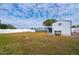 Expansive backyard featuring a covered patio, lush green lawn, white picket fence, and accessory building at 3461 Normandy Dr, Port Charlotte, FL 33952