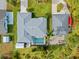 Aerial view of a home with a screened pool, lush landscaping, detached garage, and additional outbuilding at 472 Eppinger Dr, Port Charlotte, FL 33953