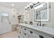 Bright bathroom featuring a dual sink vanity, lighted mirrors, and elegant fixtures at 472 Eppinger Dr, Port Charlotte, FL 33953