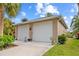 Two-car detached garage with matching exterior paint with 2 garage doors and a concrete driveway at 472 Eppinger Dr, Port Charlotte, FL 33953