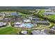 Aerial view showcasing a community pool, tennis courts, and golf course surrounded by lush greenery at 14091 Heritage Landing Blvd # 121, Punta Gorda, FL 33955