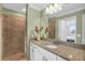 Bathroom featuring granite countertops, a shower with glass door, and decorative floral arrangements at 14091 Heritage Landing Blvd # 121, Punta Gorda, FL 33955