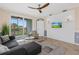 Bright living room features a ceiling fan, mounted tv, tiled floors, and a sliding glass door to a balcony at 14091 Heritage Landing Blvd # 121, Punta Gorda, FL 33955