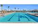 Community pool with lap lanes, lounge chairs, palm trees, and a clubhouse, perfect for relaxation and recreation at 14091 Heritage Landing Blvd # 121, Punta Gorda, FL 33955