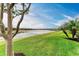 Lush backyard with a lake view, mature trees, and well-maintained lawn at 15169 Spanish Point Dr, Port Charlotte, FL 33981
