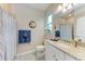 Bright bathroom featuring a granite vanity, framed mirror, and neutral tile at 15169 Spanish Point Dr, Port Charlotte, FL 33981