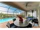 Spacious patio with a dining table, ceiling fan, and views of the pool and lake at 15169 Spanish Point Dr, Port Charlotte, FL 33981