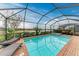 Screened-in pool with a hot tub, lounge chairs, and views of the lake at 15169 Spanish Point Dr, Port Charlotte, FL 33981