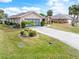 Charming single-story home features a well-manicured lawn, tropical landscaping, and a concrete driveway leading to a garage at 18305 Wolbrette Cir, Port Charlotte, FL 33948