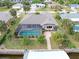 Aerial view of a home with a screened-in pool, a brick-paved walkway, and canal access at 18305 Wolbrette Cir, Port Charlotte, FL 33948